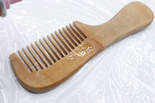 セリアの木製櫛（持ち手付き、太目）にヘアオイルをかけた様子