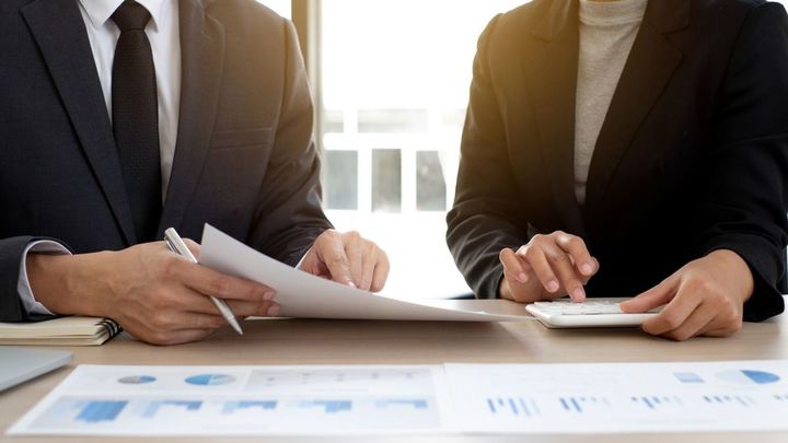 投資を計画するためのグラフで収益について話し合う2人のビジネスパーソン