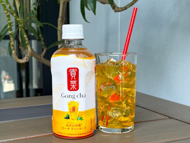 テーブルに並んだ「貢茶 阿里山烏龍ピーチティーエード」のペットボトルとグラス