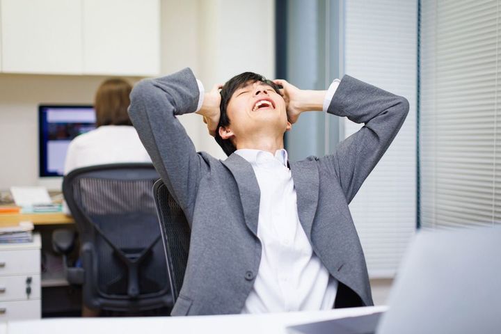 のけぞって頭をかかえるビジネスパーソン