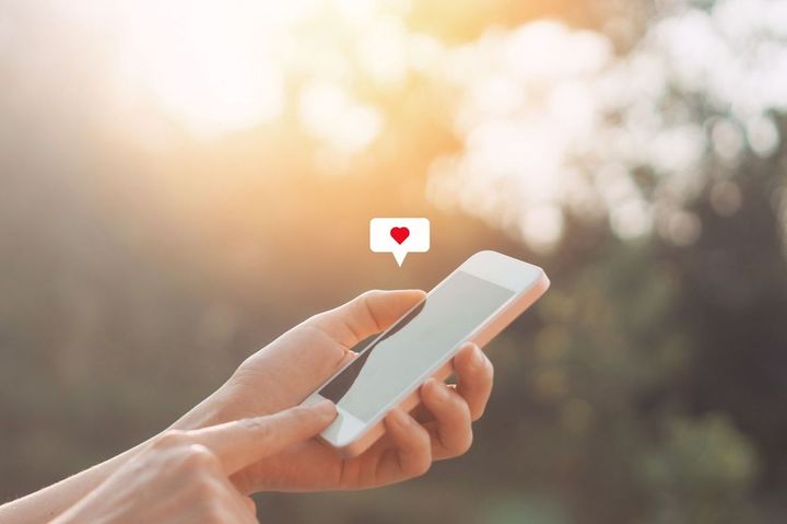 スマートフォンでハートマークのアイコンを押した人の手元