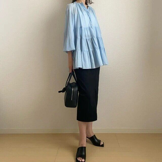 ブルーのティアードブラウスと黒タイトスカートのコーデ