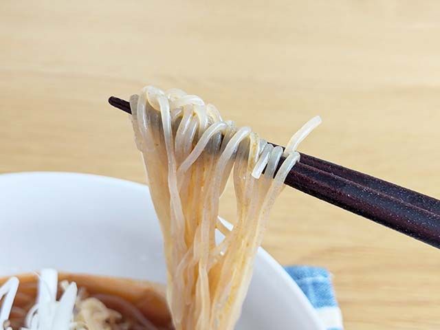 業務スーパー「トマト冷麺」の麺をお箸で持ち上げている様子