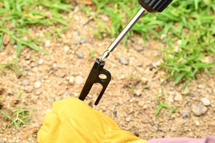 電動ドライバースクリューペグを電動ドライバーを使い地面に打ち込んでいる様子