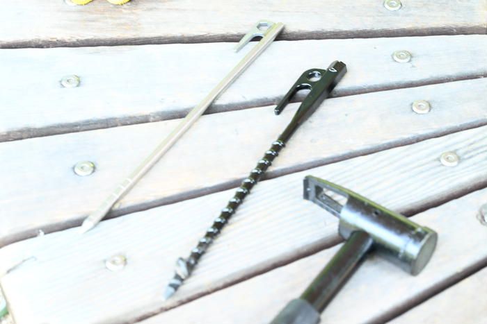 板の上に置かれたワークマンの合金ペグと黒色の電動ドライバー対応ペグ