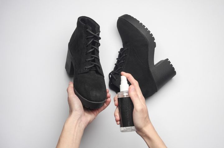 スエードのブーツに撥水スプレーをかける女性