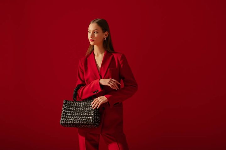 ツイードバッグを持った赤いセットアップの女性