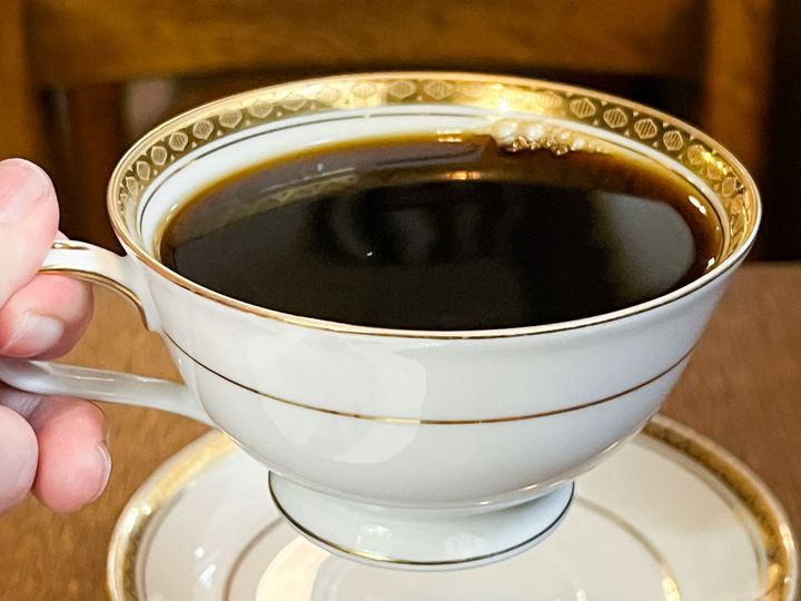 手に持ったコーヒーカップ