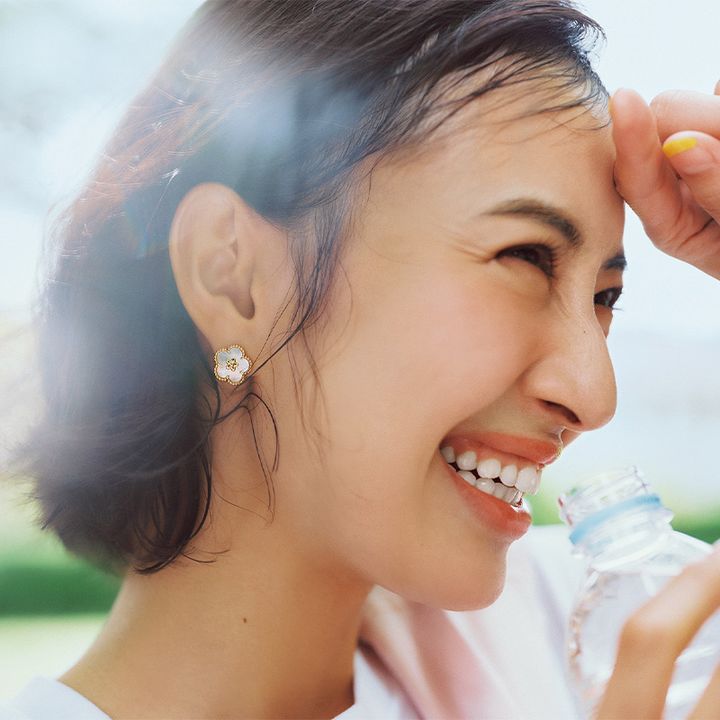 耳元にヴァンクリーフ＆アーペルの花モチーフピアスを付けた岡本あずささん