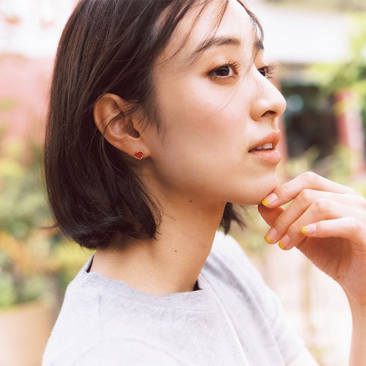 耳元にショパールのカーネリアンのハート型ピアスを付けた岡本あずさん