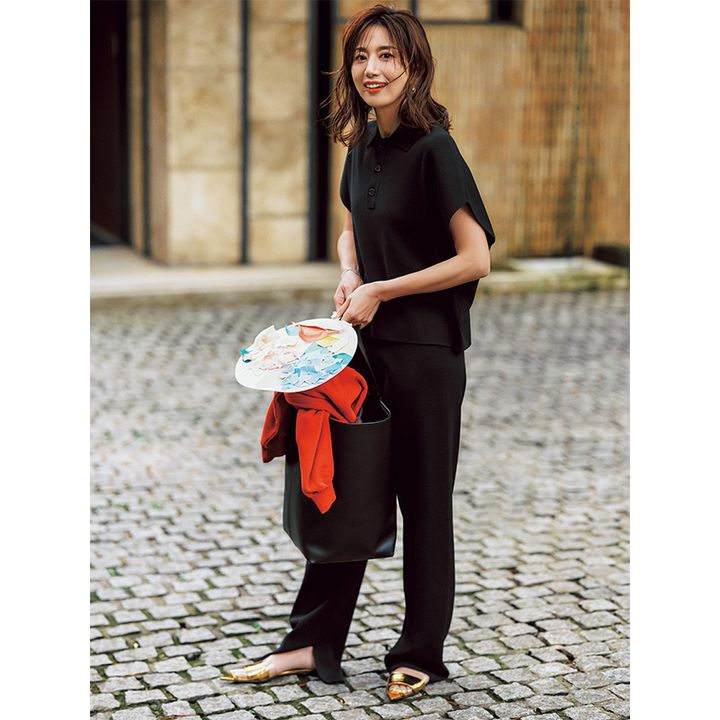 黒ポロニットとパンツのセットアップを着た東原亜希さん