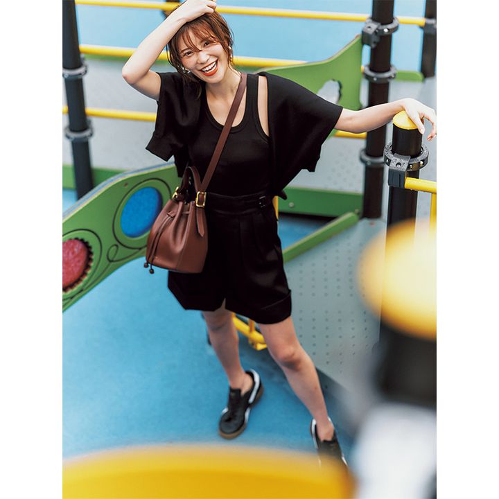 黒のタンクトップとショーパンに黒スウェットを肩掛けしたオールブラックコーデ