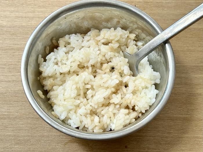 アルミの皿に入ったごはんにしょうゆとにんにくチューブを混ぜ合わせたところ