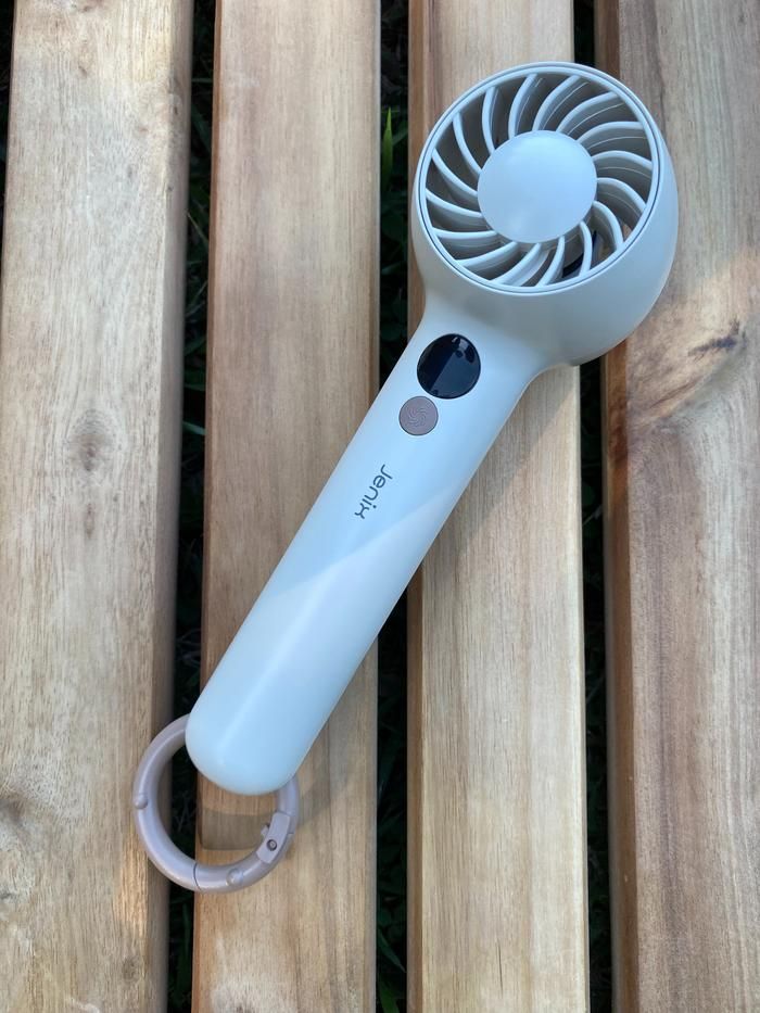 コメリのコンパクトハンディファンがウッドテーブルに置かれている