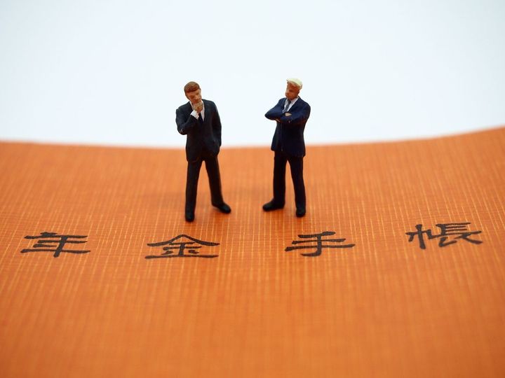 年金手帳と2人のビジネスマン