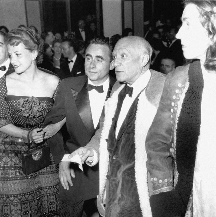 Image may contain_ Human, Person, Clothing, Apparel, Coat, Suit, Overcoat, Tie, Accessories, Accessory, and Tuxedo