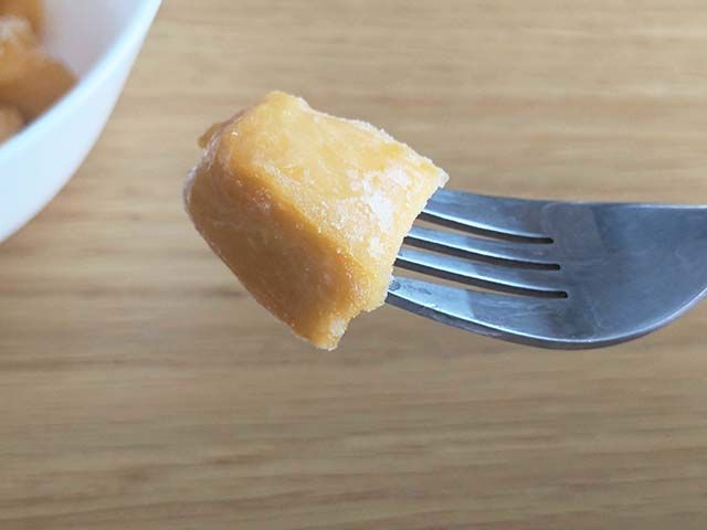 【業務スーパー】の冷凍フルーツ「カットマンゴー」をフォークで刺している様子