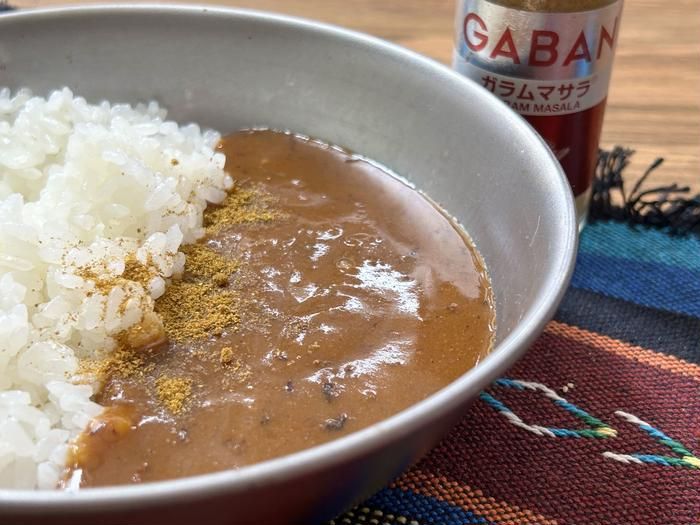 銀色の器にガラムマサラをちょい足ししたレトルトカレーが入っているところ