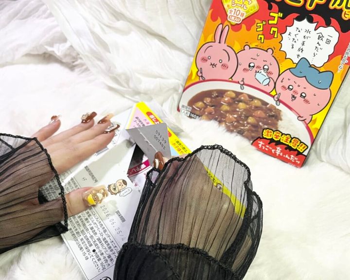 「期間限定 ちいかわ鬼辛カレー＜ビーフ＞」のパッケージを机に置いて両手で開封する画像