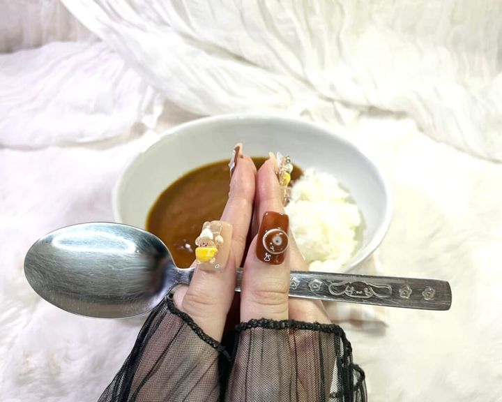 「期間限定 ちいかわ鬼辛カレー＜ビーフ＞」を調理し、皿に盛り付けたカレーに向かって両手で1本のスプーンを持ち、「いただきます」と手を合わせている画像