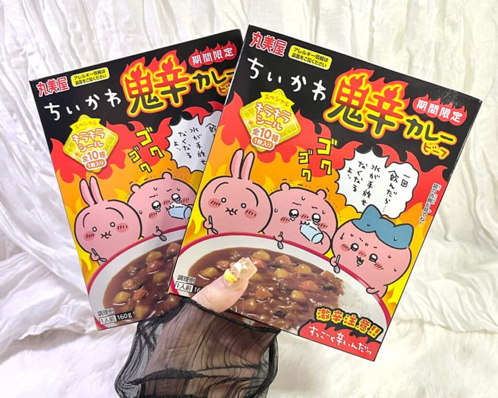 丸美屋の新商品「期間限定 ちいかわ鬼辛カレー＜ビーフ＞」を2個手に持っている画像