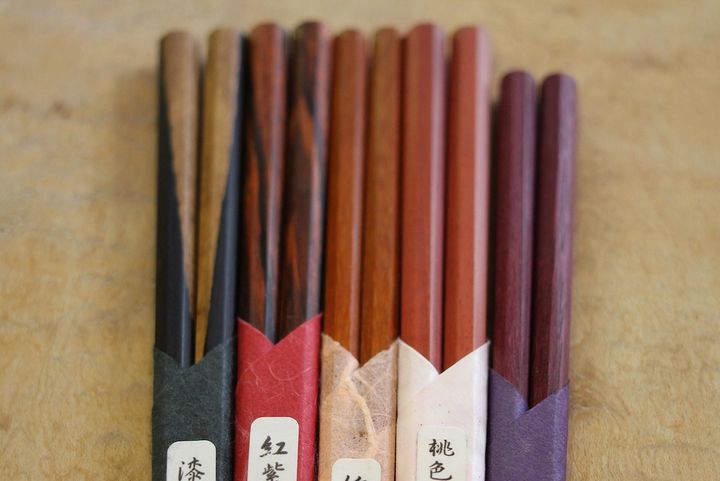 左から「ブラックウッド」「紅紫檀」「カーディナルウッド」「ピンクアイボリー」「パープルハート」の木材を使用した箸