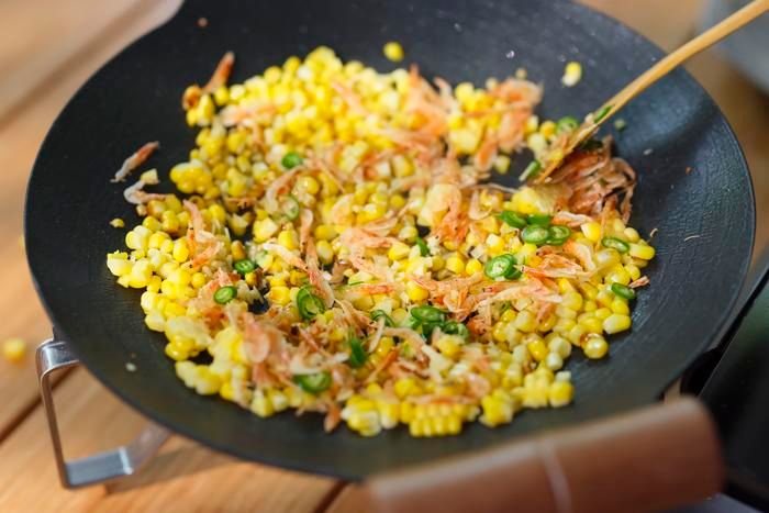 桜エビ、ショウガ、青唐辛子を加えて炒め合わせている様子