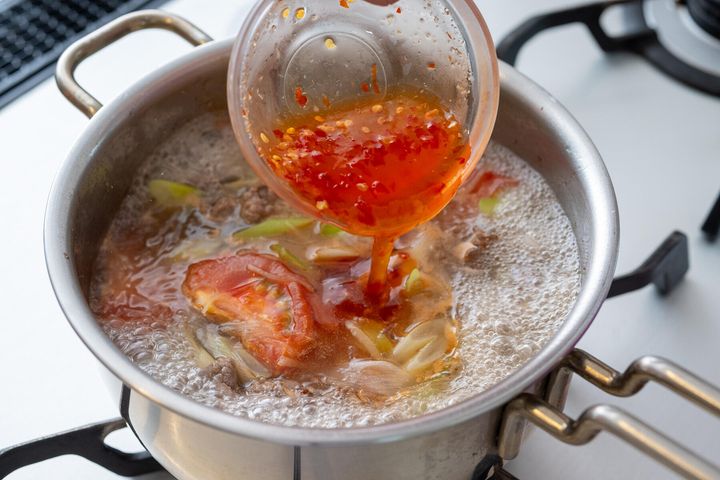 トマトを加えて味つけする