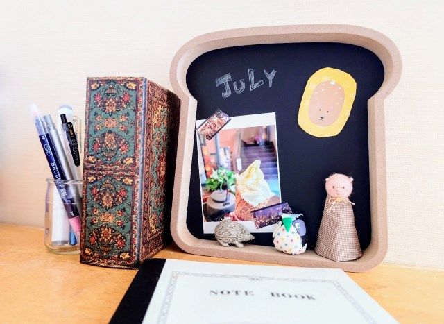 ナチュラルキッチン アンド「ブラックボードトースト」に小物や写真を貼ってデスク周りに飾った様子