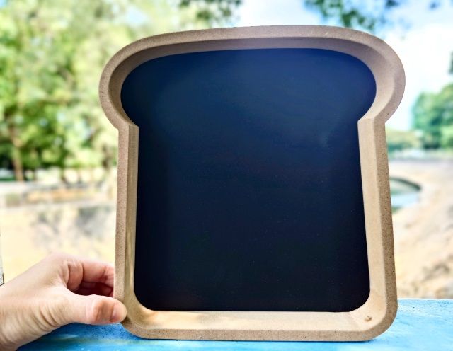 ナチュラルキッチン アンド「ブラックボードトースト」を手に持っている様子