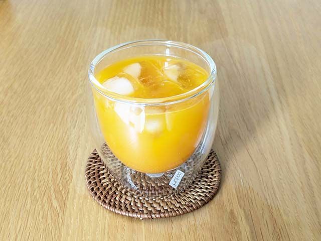 コップに入った水で割ったサジージュースがテーブルに置かれている様子