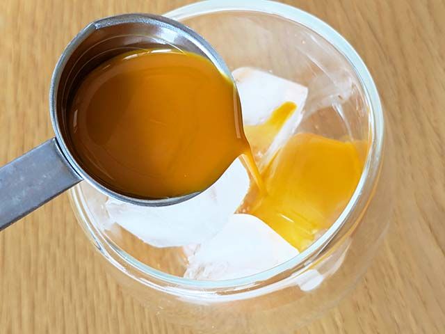 業務スーパー「サジージュース」30mlを氷の入ったコップに注いでいる様子