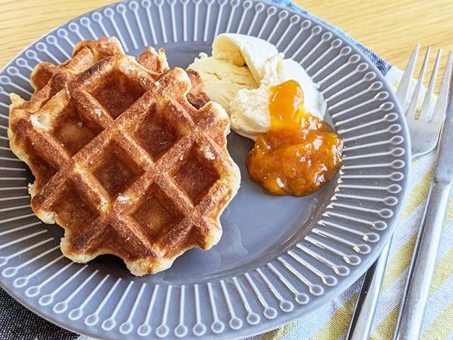 お皿にのせられた【業務スーパー】「ベルギーワッフル」にバニラアイスとあんずジャムが添えられている様子