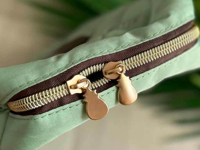 パールグリーンにゴールドのジッパーが映える