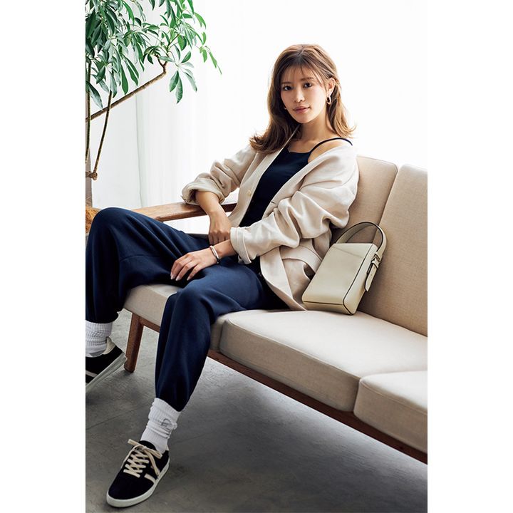 ベージュジャケットのインナーに細ストラップのキャミを合わせてスウェットを穿いた今どきコーデ