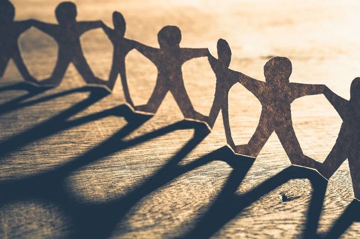 たくさんの人がつながった形に切った紙