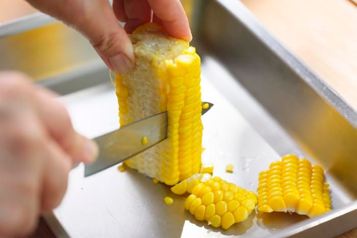 トウモロコシの実をこそげ落としている様子