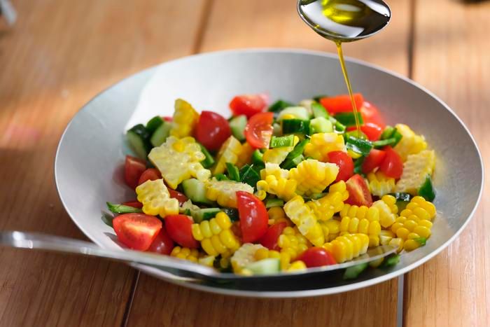 野菜にオリーブオイルをかけている様子