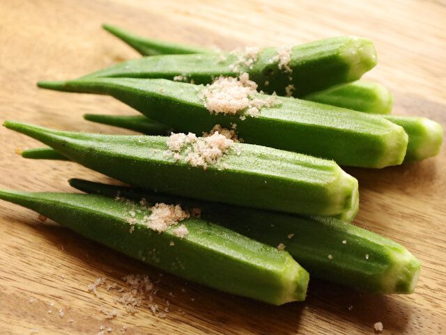 オクラに塩を振りかけ、まな板にこすりつけて転がして産毛を取る。