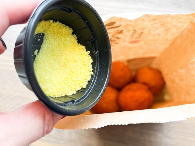 「丸亀うどーなつ」 の袋に「塩パイン味」のフレーバーを入れる様子