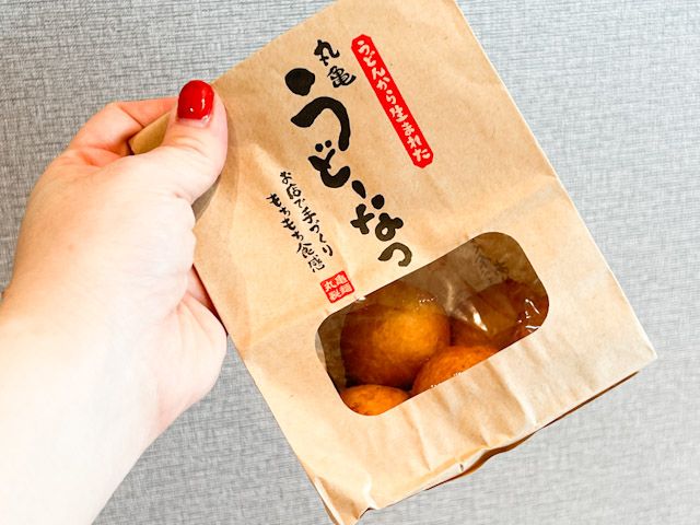 「丸亀うどーなつ」の袋を振る様子