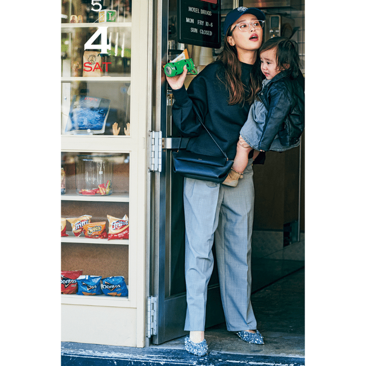 スウェットトップス×グレーパンツの近藤千尋さんが赤ちゃんモデルを抱っこしている写真