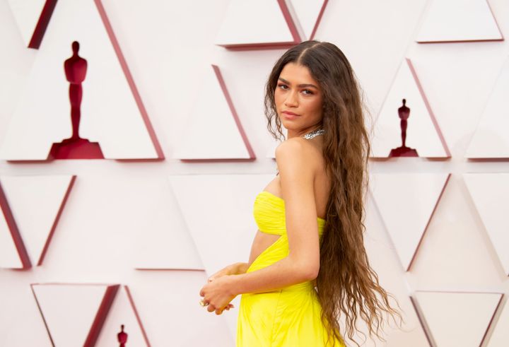 Image may contain_ Zendaya, Clothing, Dress, Adult, Person, Indoors, Interior Design, Formal Wear, Symbol, and Evening Dress