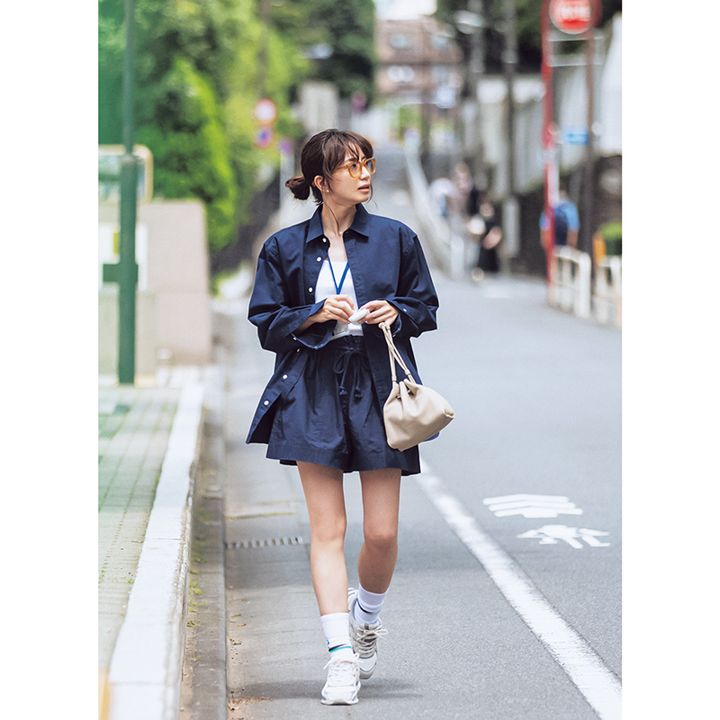 ネイビーシャツ×ショーパン×白スニーカーを履いた東原亜希さんの写真