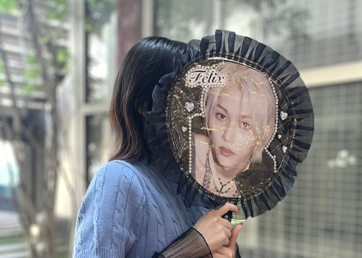 3COINS（スリーコインズ）「フリルうちわカバー」に韓国アイドルグループ「Stray Kids」のメンバー・フィリックスの自作うちわをセットし、顔が隠れるよう手に持った状態で紹介する画像