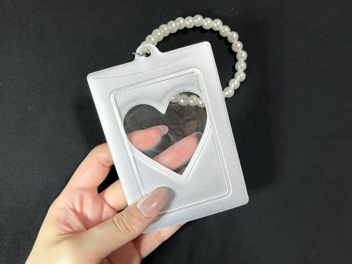 3COINS（スリーコインズ）「PVCトレカホルダー」の裏面を手に持って紹介する画像