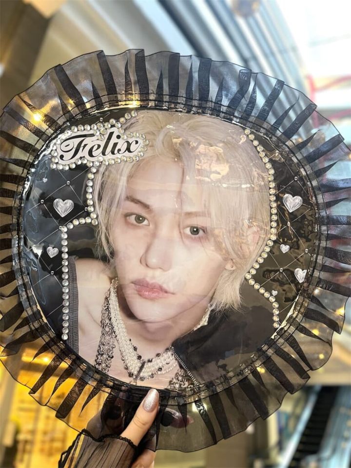 3COINS（スリーコインズ）「フリルうちわカバー」に韓国アイドルグループ「Stray Kids」のメンバー・フィリックスの自作うちわをセットし、手に持った状態で紹介する画像