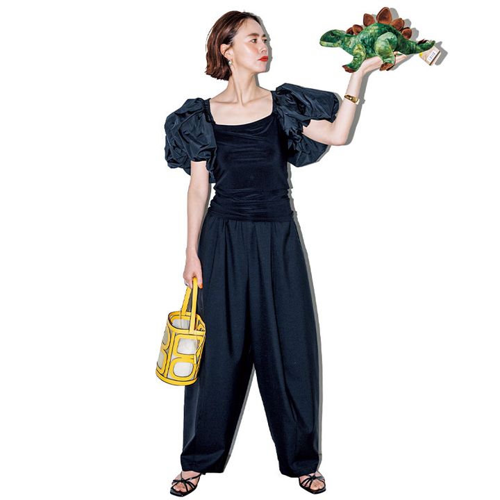 デコルテが大きく開いたボリューム袖Tシャツとパンツを合わせた全身黒コーデ