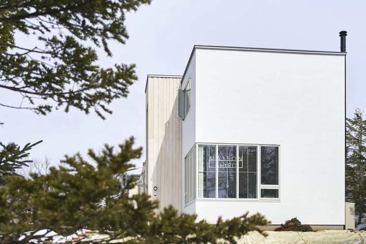 自然の景観を壊さないシンプルな外観。冬は白い壁が雪と一体化する。