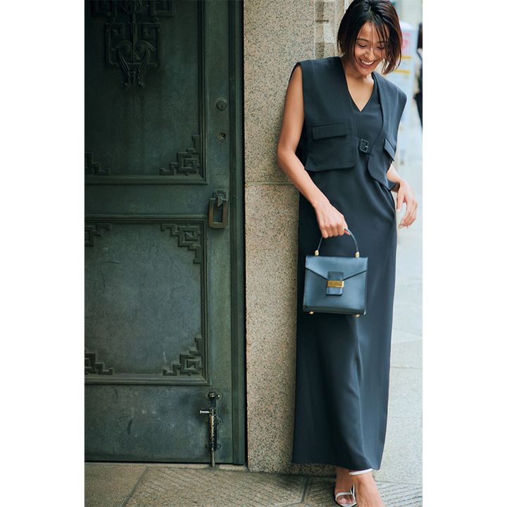 リムアークのベストをレイヤードしたデザインのワンピースを着るモデル